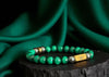 Rengetsu Ryokuken Green Blade luxury Malachite men’s bracelet 18 cm displayed on black stone with draped green satin background – signature piece photoshoot